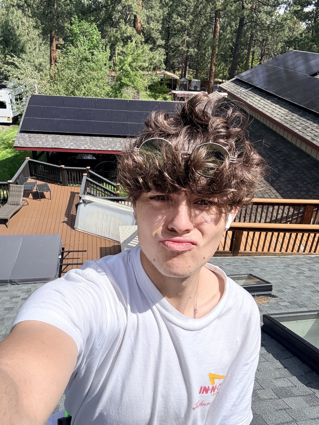 Kai Williams on a roof next to freshly washed solar panels in Bend